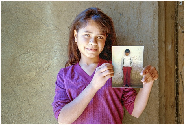 Girl holding the photograph I took of her six years before, Batopilas