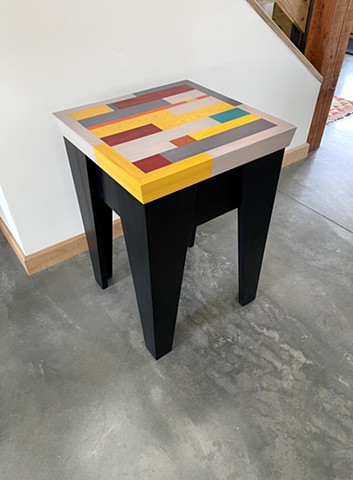 Modern Apollo Table with a black stained pine base and multi-colored cypress wood top by Andrew Traub Studio. 15" sq x 21".