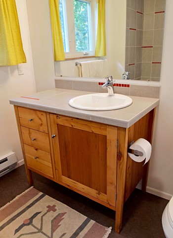 Handmade bath vanity from salvaged reclaimed wood with tile top.