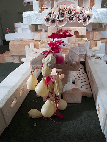 detail of deflated balloons and vacuum molded plastic, cupcake papers, nail polish, ribbons and rose petals