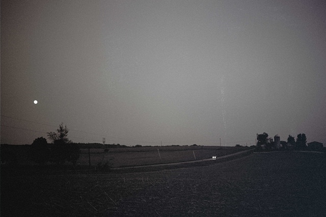 ohio black and white moonrise over farm and road with car. 