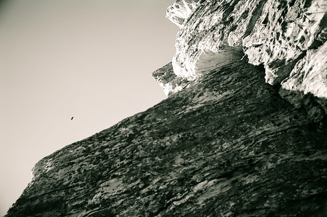 hanging rock black and white with rock in right of frame with bird in sky horizontal. 