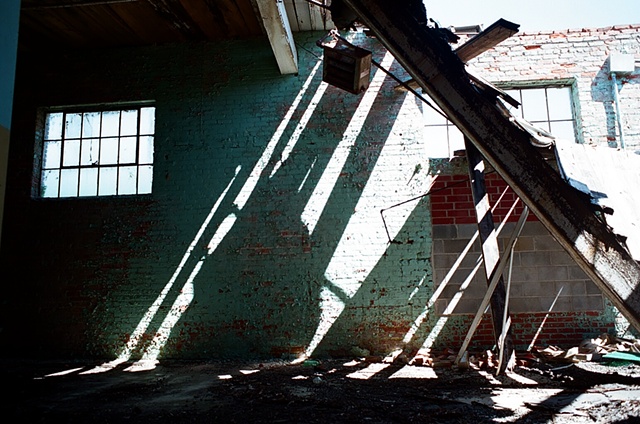 cone mill light falling right to left agains blue wall with hole in roof. 