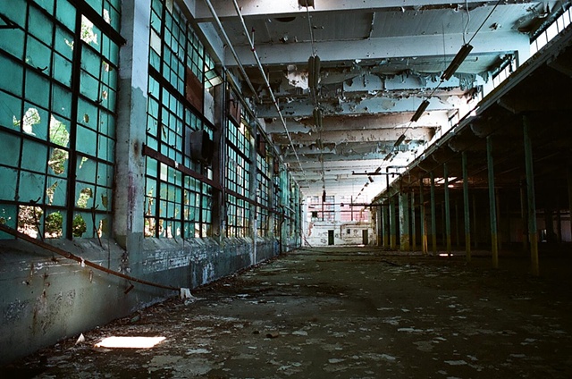 cone mill interior blue wall of windows on left with light projection in foreground.