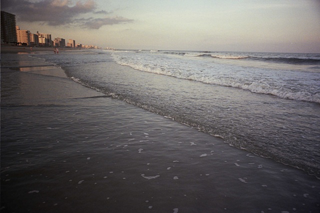 east coast low light water coming in on right couple and buildings on left.