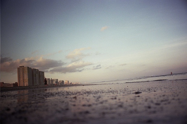 east coast low light buildings on left low angle on water child in water on right.