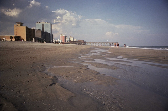 east coast with buildings on left and pier by inland water.