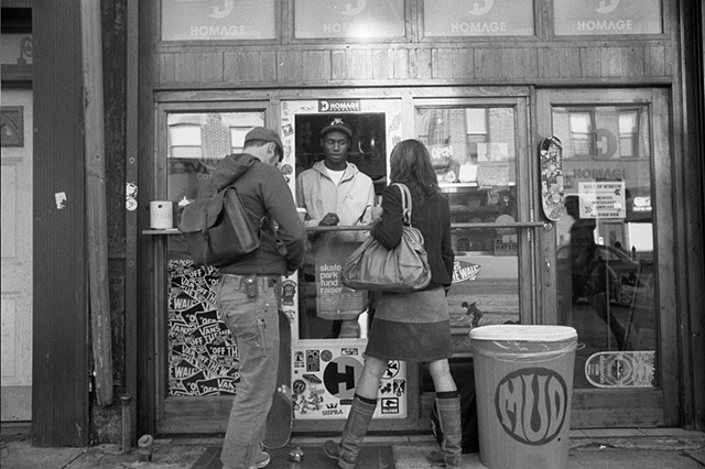 NYC 2009 skateboarder and girl by coffee window. 