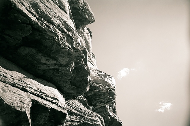 hanging rock black and white rocks from left two clouds on right. 