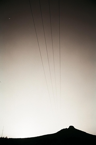 pilot mountain with crescent moon and powerlines.