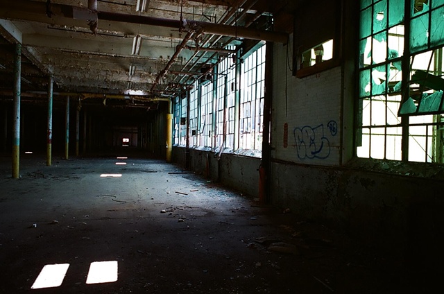 cone mill interior blue and green to right trail of light projection to distance. 