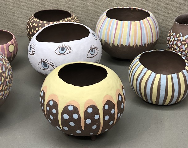 Greenware Clay vessels with first application of underglaze applied.