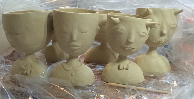 Porcelain people cups before being fired.