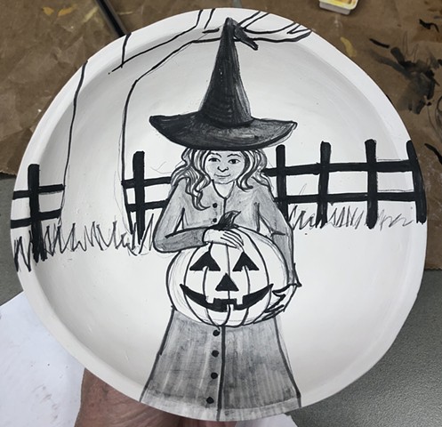 Drawing Halloween imagery on a greenware porcelain bowl.