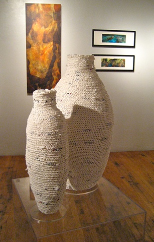 White vessels with paintings in the background.