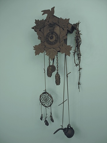 “Black 13”; cuckoo clock, barbed wire, dream catcher, and oil can.