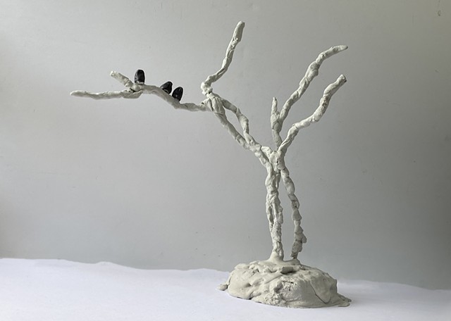 Small resin and concrete sculpture of blackbirds in snow covered tr.ees 