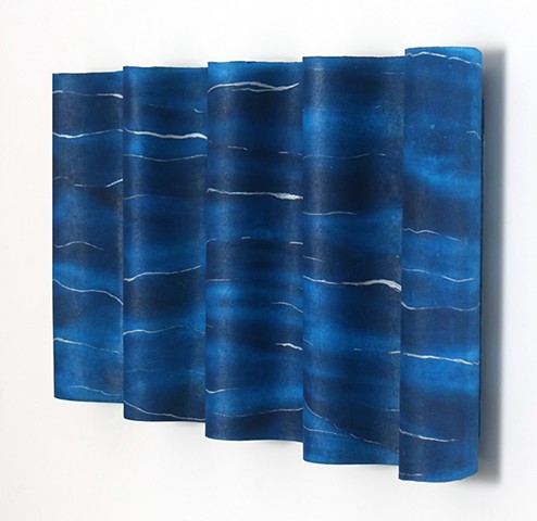 Wavy abstract wall sculpture in blue and white representing the sea