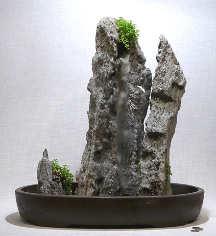 tabletop fountain with feather rock mountains, plants, miniature figures, and fogger