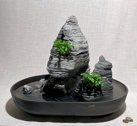 indoor fountain made of feather rock pieces, with miniature pump, fogger, and live plants 