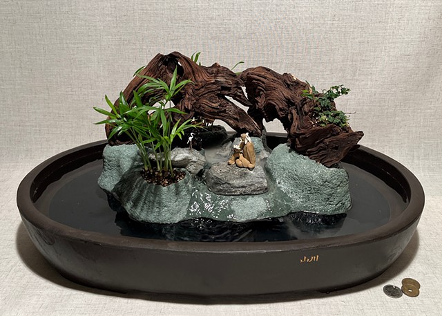 tabletop fountain with driftwood, feather rock, miniature bird and Chinese figurine, plants, waterfall, and mist