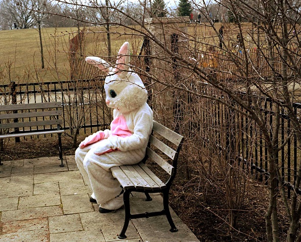 Photograph of person in Easter Bunny costume caught in a provate moment looking sad or hungover in a Chicago park photographed by lucy mueller