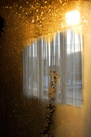 Crystals of frost on a window with harsh sun shining through photographed by Lucy Mueller