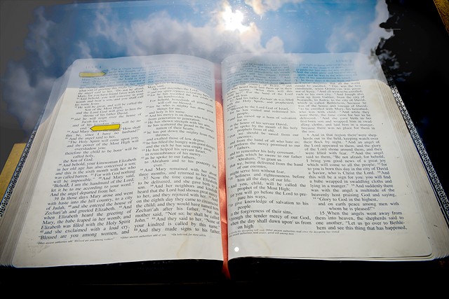 a bible is open to scripture as the reflection of the heavans surrounds it
