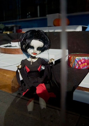 Goth punk doll with black hair and a nose piercing  in the window of a jewelry store on Milwaukee Ave in Chicago photographed by Lucy Mueller
