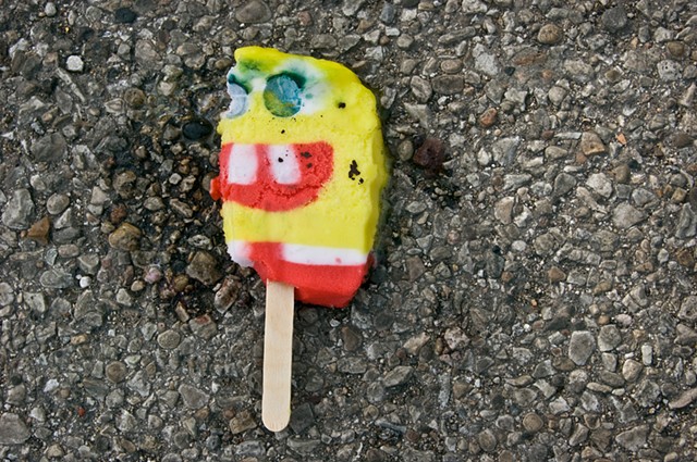 a squished sponge bob ice cream treat lies on the pavement photographed by lucy mueller