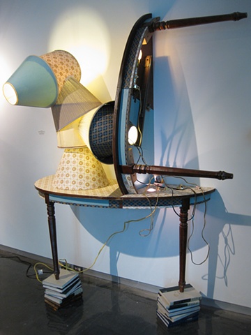 Title/Materials: Table, Lamp Shades, Lamps, Light Bulbs, Wallpaper, Electrical Receptacle, Electrical Wiring, Door Hinges, Books  