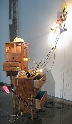 Title/Materials: Chests of Drawers, Lamps, Light Bulbs, Crutches, Surge Protector, Circuit Taps, Artificial Flowers, Paint, Sawdust, Wood Glue, Extension Cord