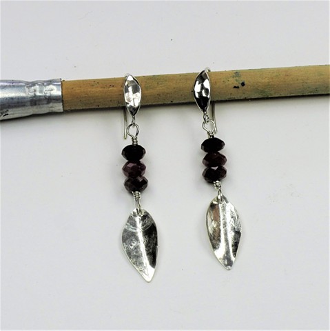 a textured silver leaf hangs from 3 faceted ruby rondels on sterling  hammered leaf ear wire (hangs 1 1/2") (#691E)