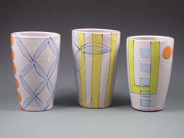 group of thrown terra-cotta tumblers, with handpainted majolica glaze