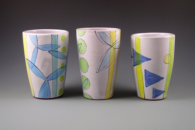 group of thrown terra-cotta tumblers, with handpainted majolica glaze