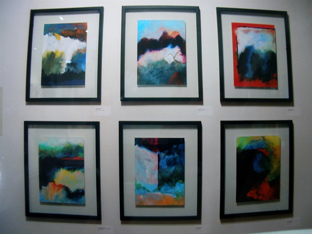 wall of six small painitngs at gallery 100, in see-through frames