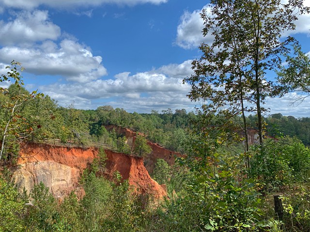 Landscape photograph of red canyons and blue skies overlooking Providence Canyon State Park. 