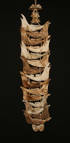 This is a modern contemporary mixed media sculpture of a vertical rhythm with mandible bones of cows by Denis A. Yanashot