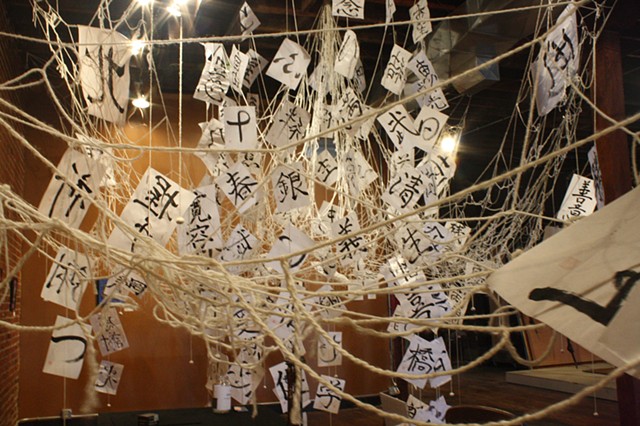 installation art with Japanese calligraphy and threads