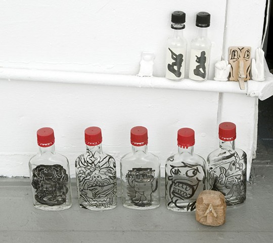 bottles with drawings inside or drawn on using sumi ink.