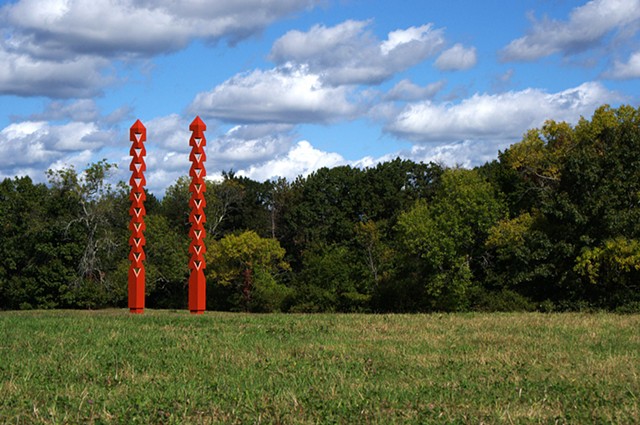 External Link - a pair of carved rhythmic obelisks frame views, imply an axis, and become a gate 