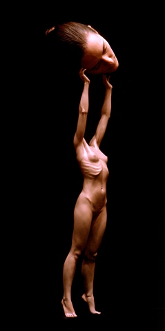 A tiny sculpted body lifts a woman's head