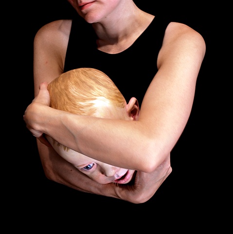 arms holding a sculpted child's head