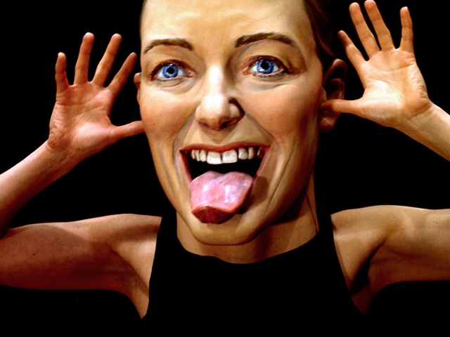 cibachrome of a woman with an oversize sculpted head sticking its tongue out