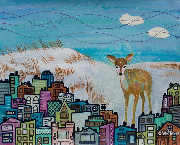 A deer stands atop a colorful city in this original painting by Chai Wolfman. There are snowy sand dunes in the background, with stitched wind details in a blue sky.  