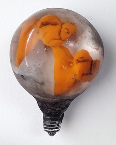 Cast glass light bulb and encased cast glass goldfish. Glass narrative. Storytelling.  Surrealism.