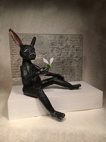 Cast glass black rabbit with a glow worm inspired by a dream.