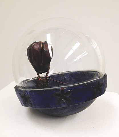 Cast glass toy with a hot air balloon.Glass narrative. Storytelling.  Surrealism.