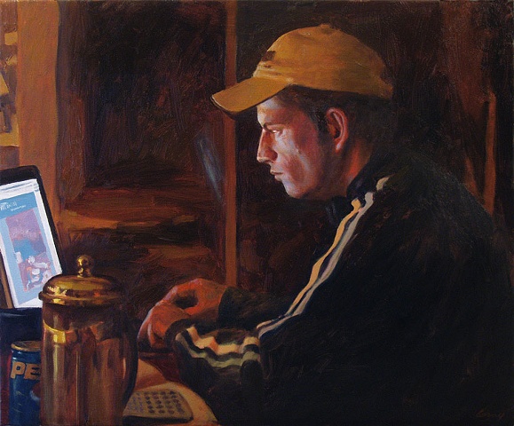 Night Interior with young man at laptop computer, glow on face.