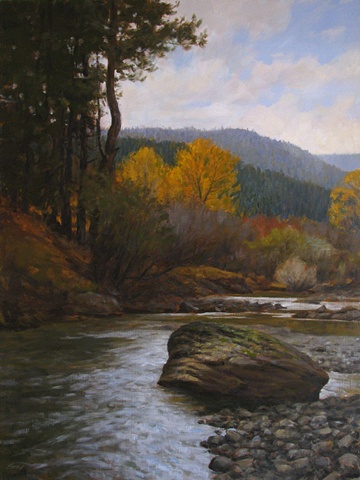 Fall landscape, evergreen forest with yellow cottonwoods, stream and boulder. 